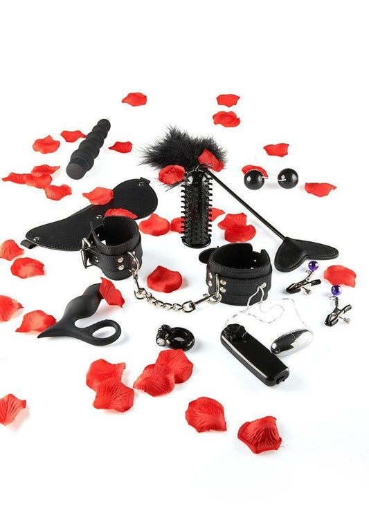 Sex toy kit with cuffs, blindfold, vibrator, and red rose petals on white background