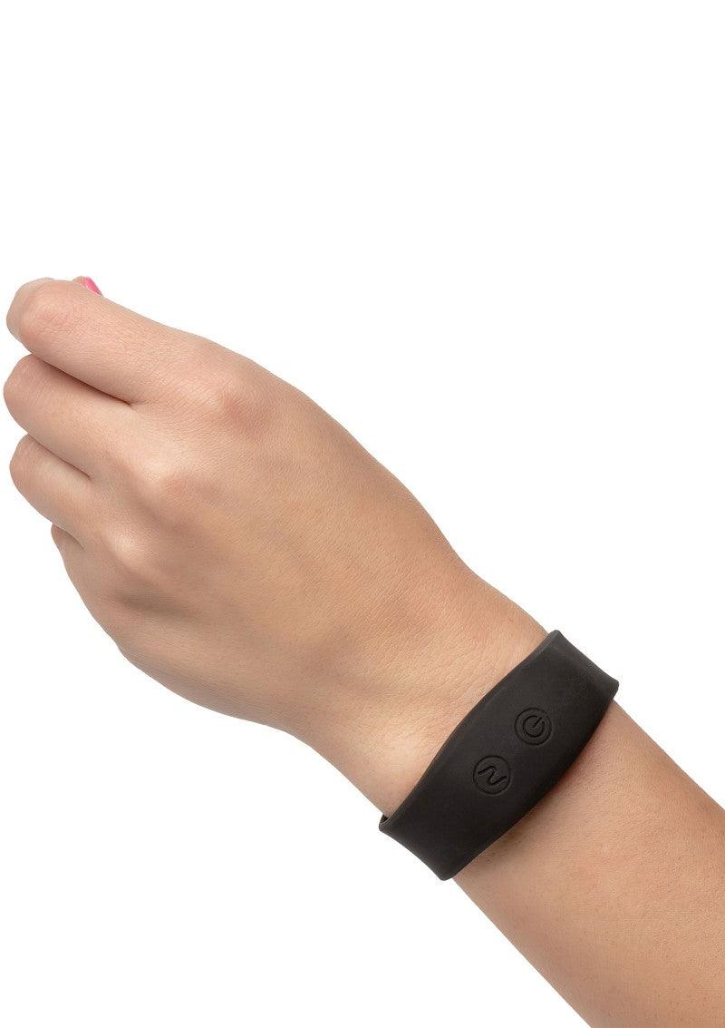 Hand wearing a black silicone wristband with two buttons on a white background