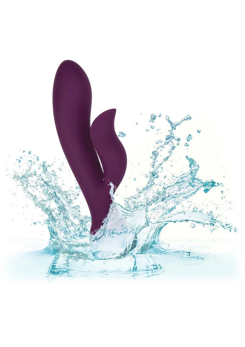 Purple dual-stimulation silicone vibrator splashing in water representing waterproof feature