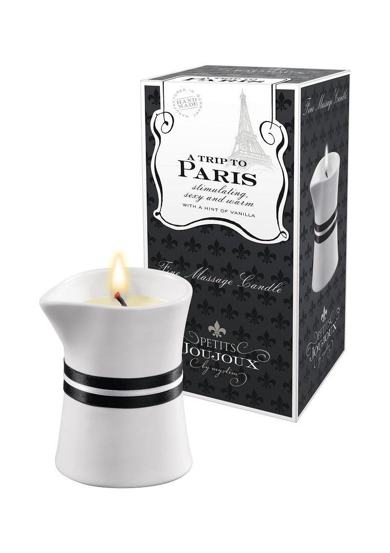 White fine massage candle with black ribbon and elegant packaging labeled A Trip to Paris vanilla scented