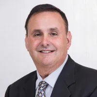Smiling man in business suit and tie with white background, professional headshot