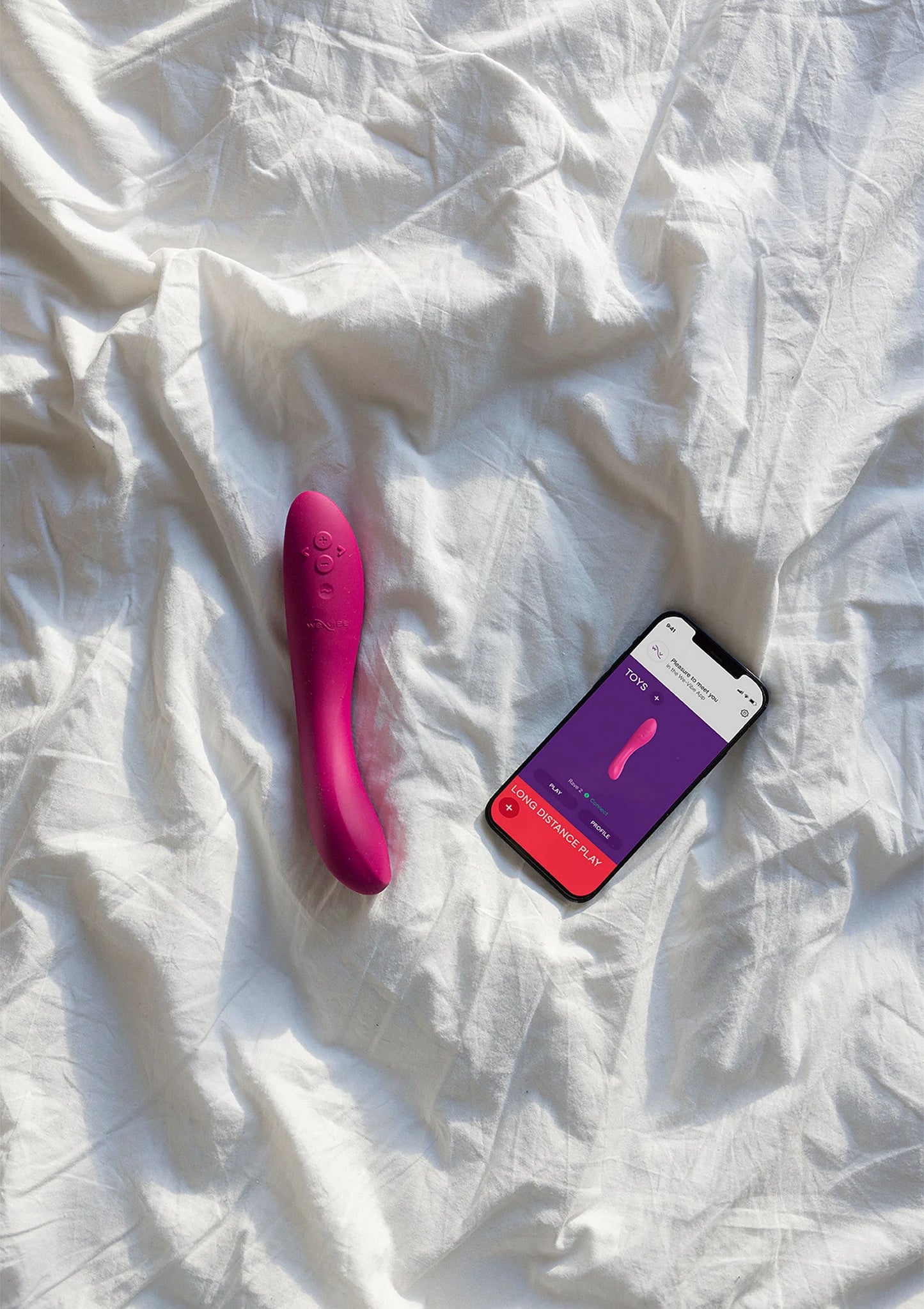 Roze vibrerende stimulator op bed met smartphone en productkaart