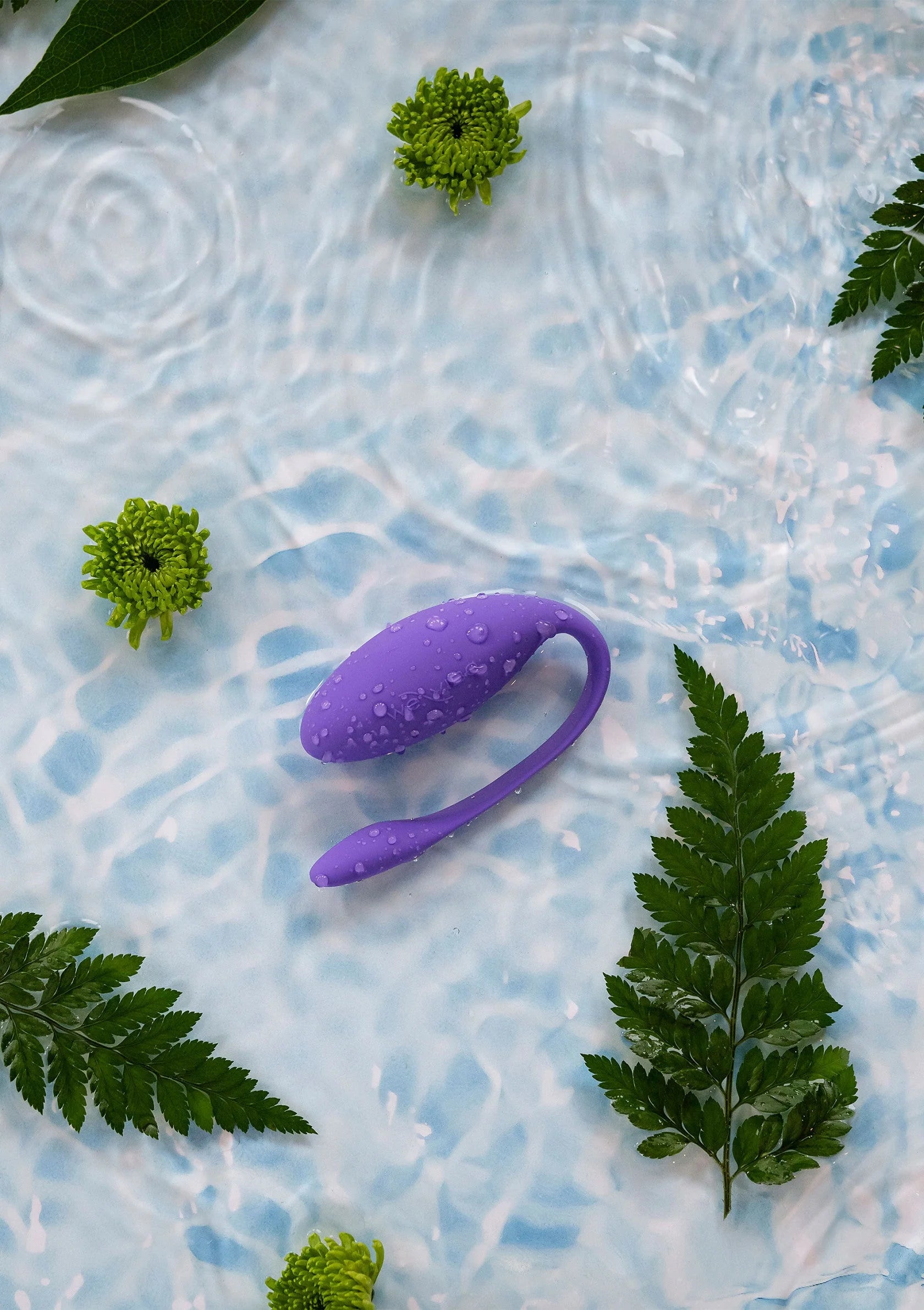 Paarse U-vormige vibrator in water met zichtbare druppels