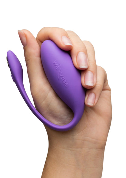 Paarse U-vormige vibrator in hand met afgeronde, zachte kop en beugel