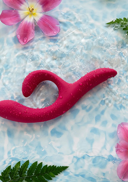 Nova 2-vibrator in magenta met waterdruppels in zwembad, bij roze bloem