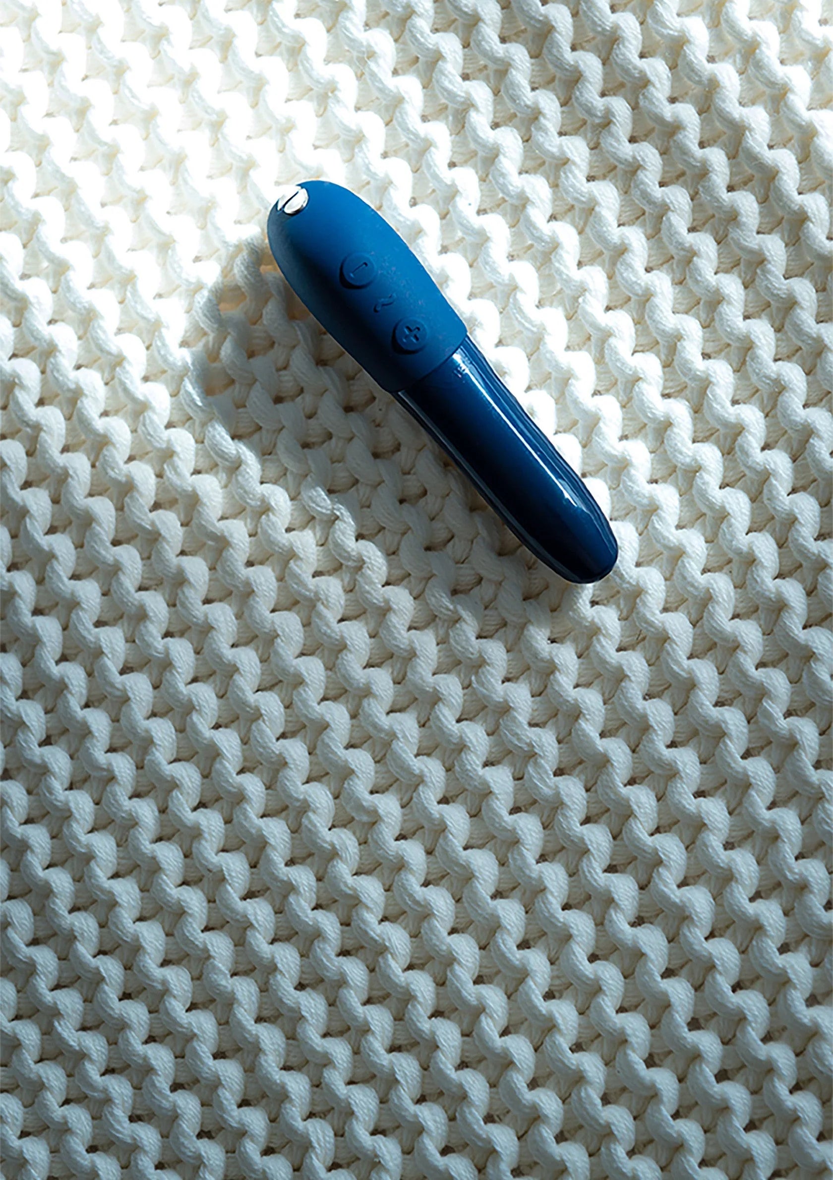 Blauwe vibrerende capsule op wit textiel