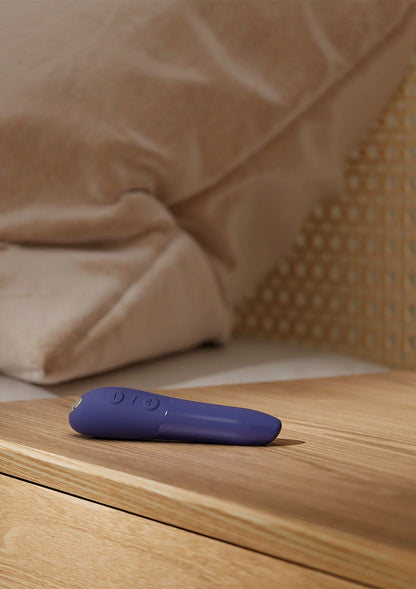 Paarse vibrerende capsule op houten plank