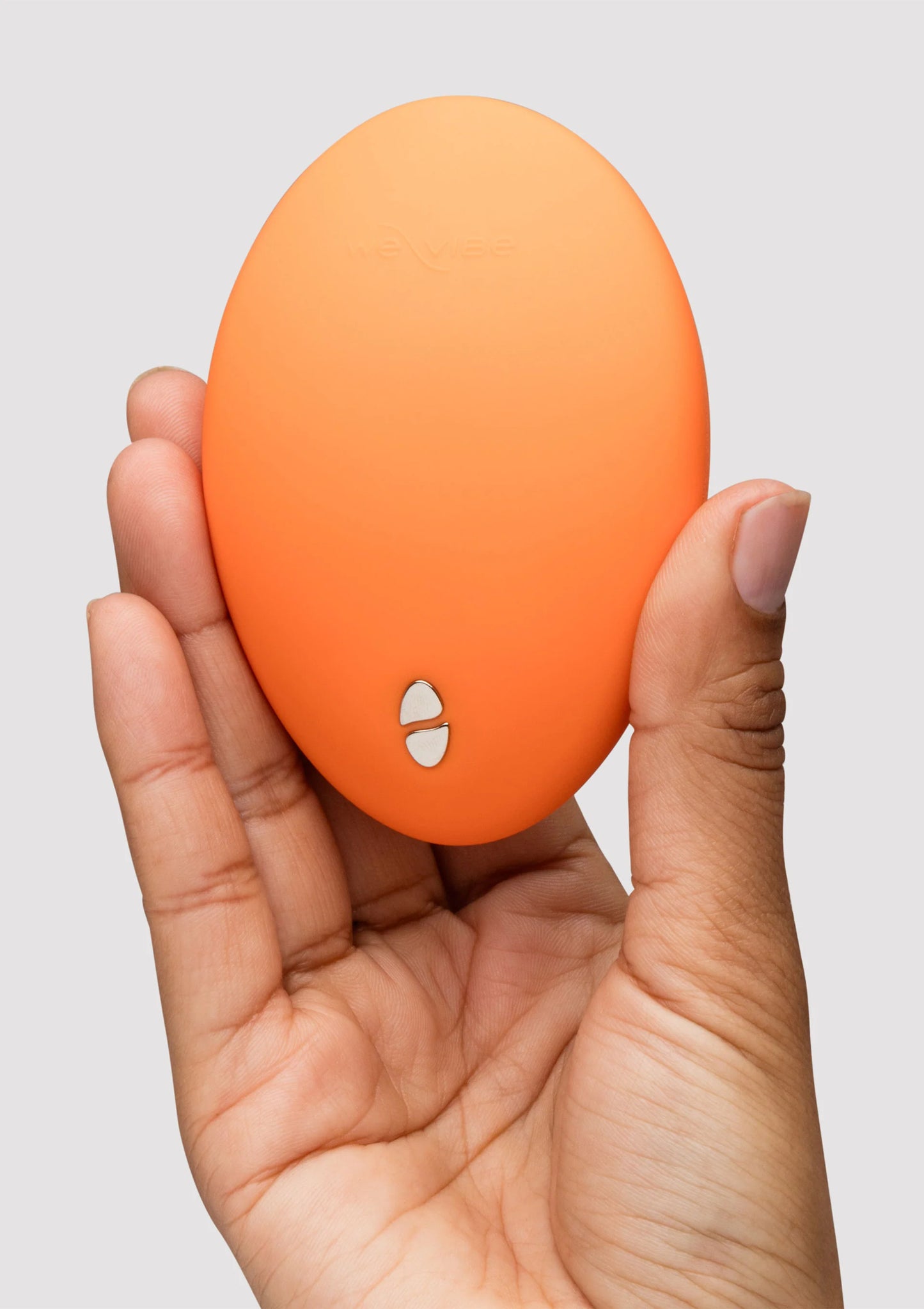 Oranje Temp massager in hand, onderzijde met kleine ronde knoppen