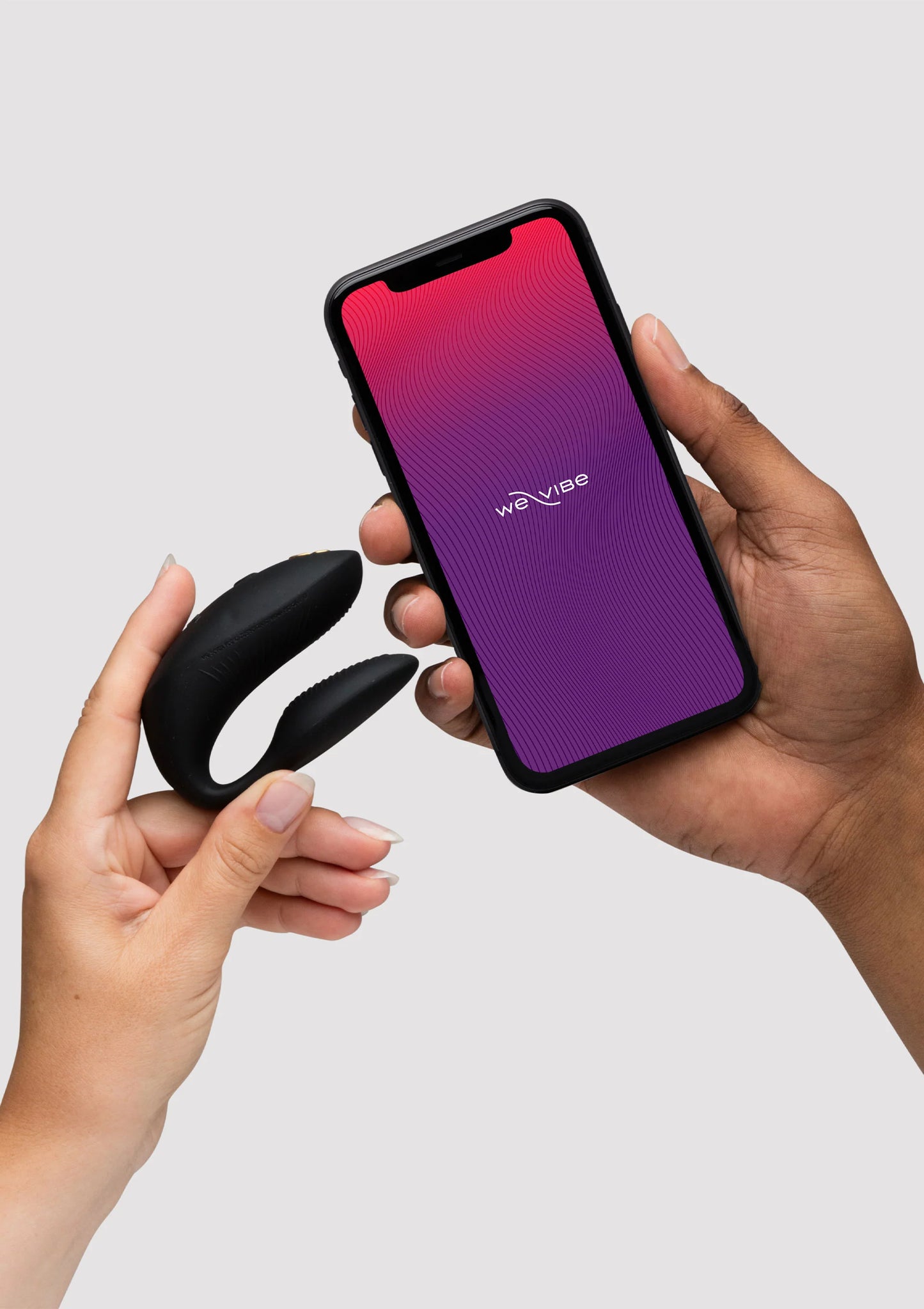 Zwarte vibratorringen naast smartphone met app-scherm in paars en rood