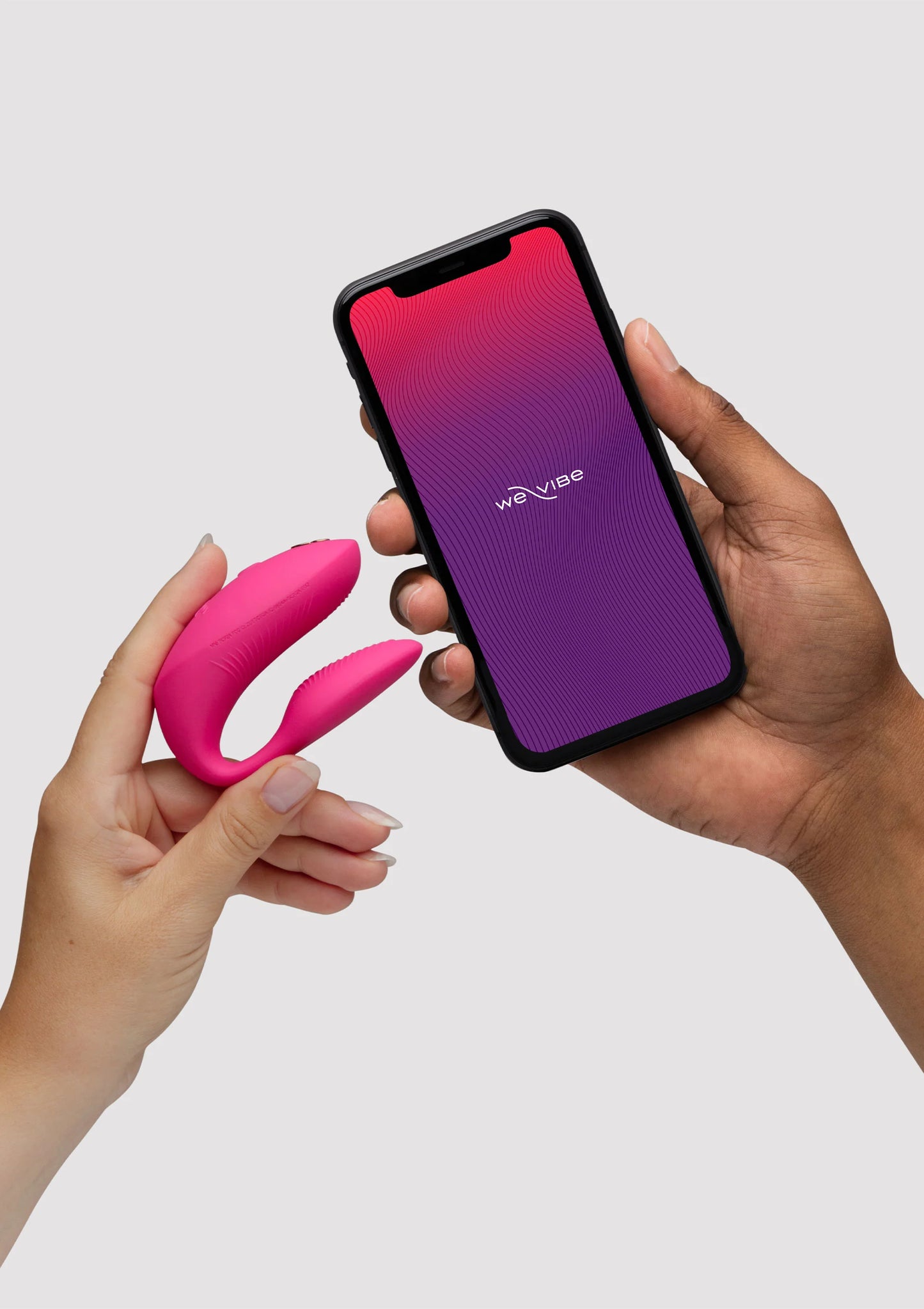 Chorus Pro van We-Vibe, roze koppelvibrator met app op smartphone