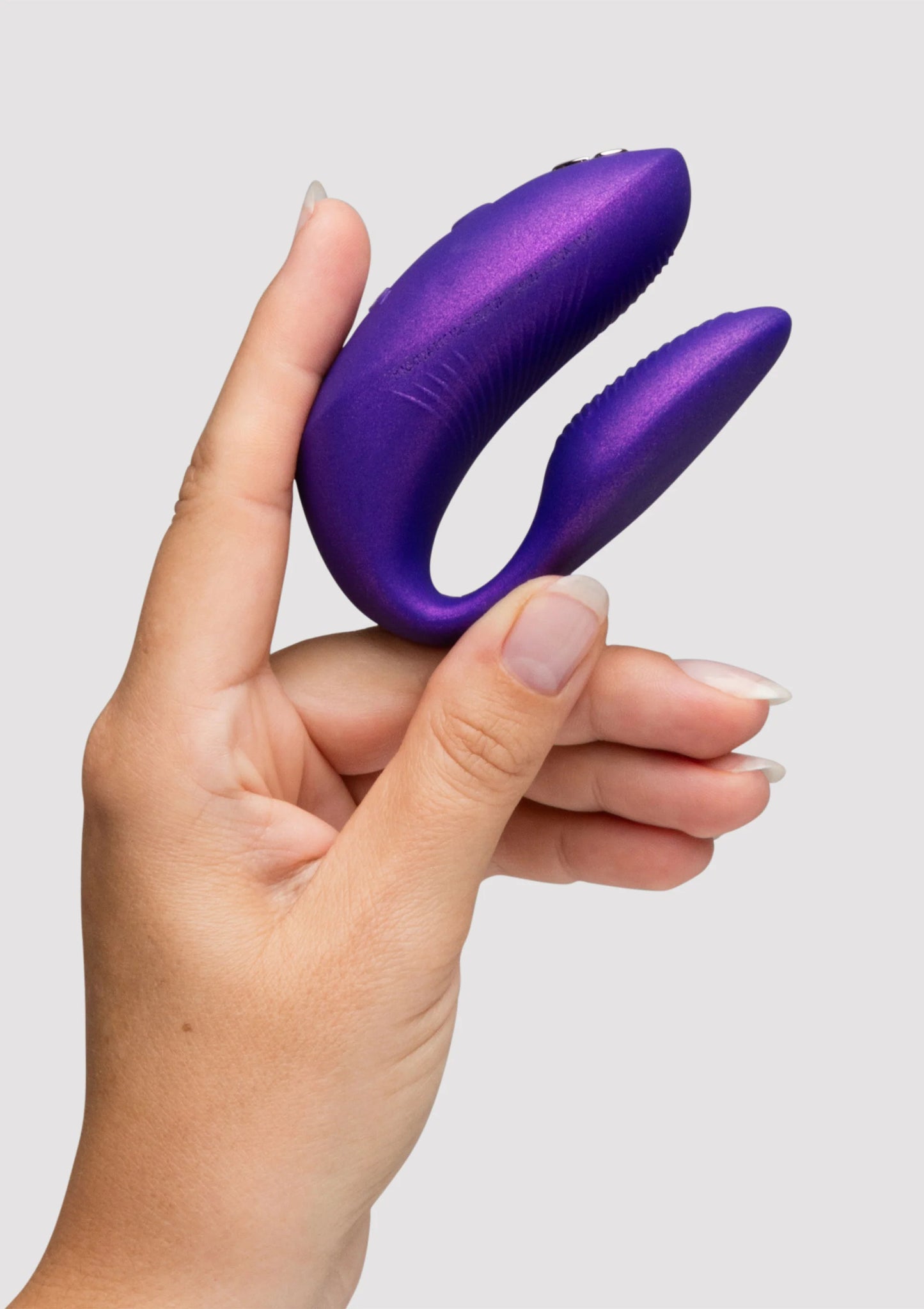 Paarse dubbele vibrator met afgeronde uiteinden, vastgehouden in één hand