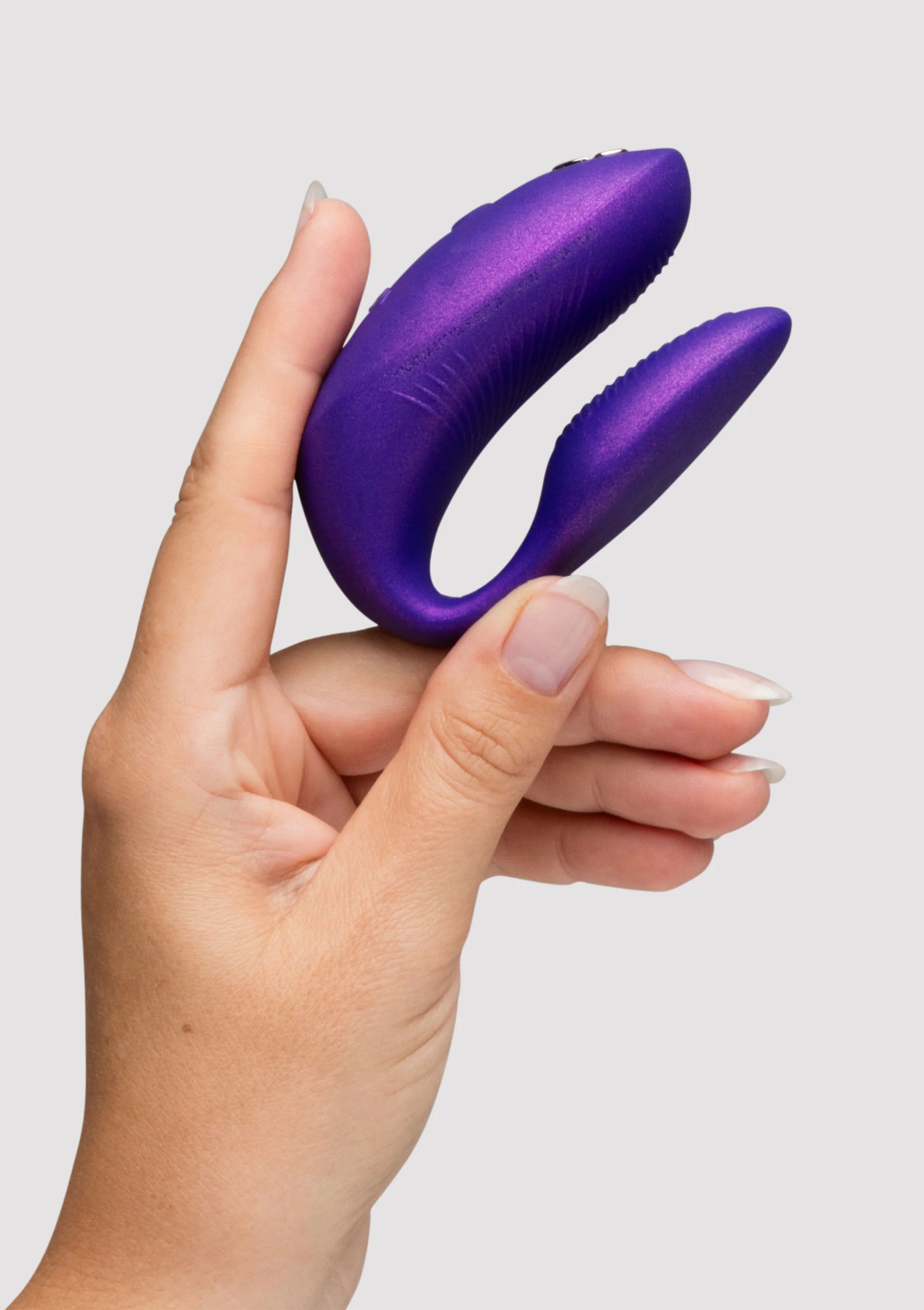 Paarse dubbele vibrator met afgeronde uiteinden, vastgehouden in één hand