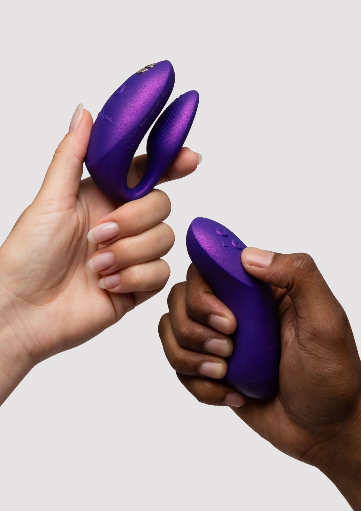 Paarse dubbele vibrator in twee handen, compacte ovalen vorm