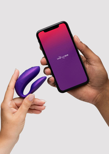 Paarse dubbele vibrator en telefoon met app, set in handen
