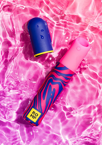 Airpressure-lipstick van Romp op roze/glanzend oppervlak, felroze en donkerblauwe huls