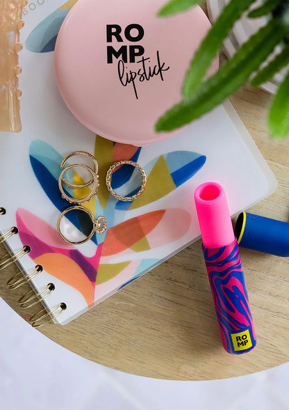 Airpressure-lipstick van Romp naast make-uptablet, roze deksel met RO MP-logo