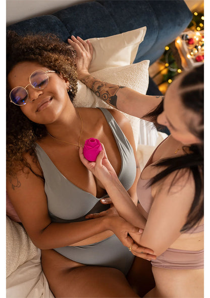 Roze lucht-druk massager in de hand, op de huid geplaatst tijdens gebruik