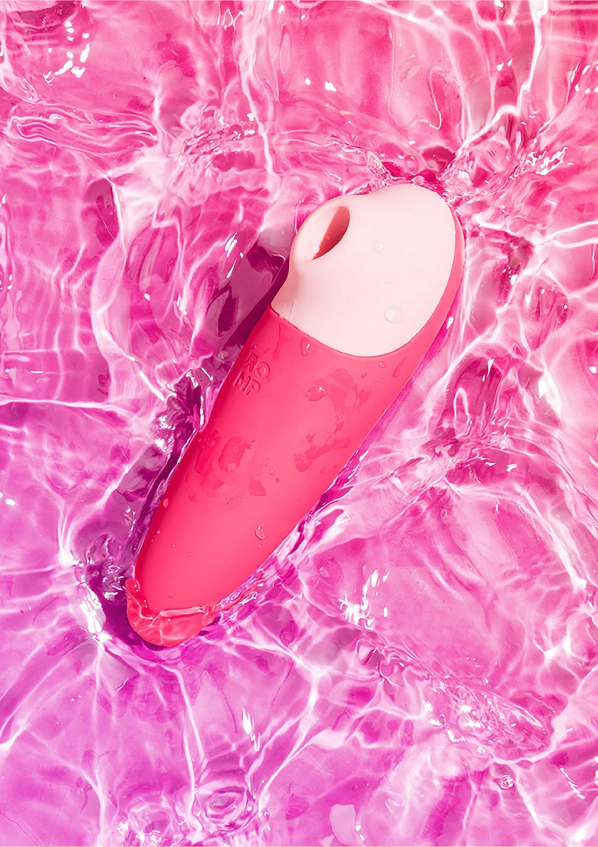 Roze vibrator met ronde kop in felroze water, met zichtbare druppels en golfpatronen.