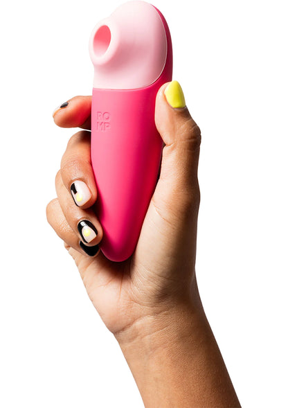 Roze vibrator vastgehouden in hand; ronde kop en body van het apparaat zichtbaar.