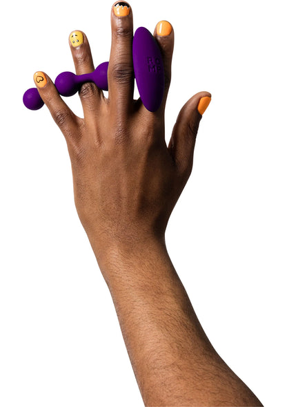 Hand met paarse Romp buttplugs en andere paarse varianten