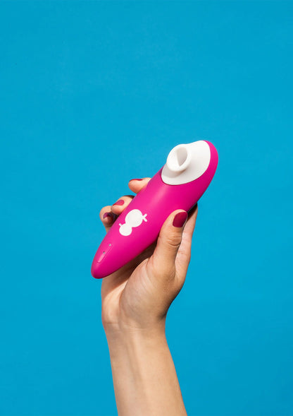 Roze vibrator vastgehouden, wit opzetstuk bovenop