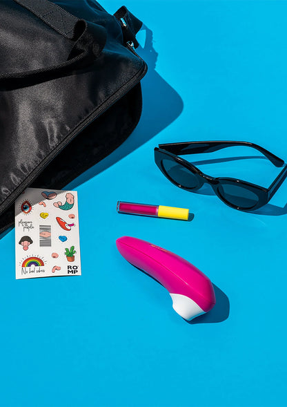 Roze lucht-druk vibrator met wit opzetstuk en zwarte kabel, accessoires erbij