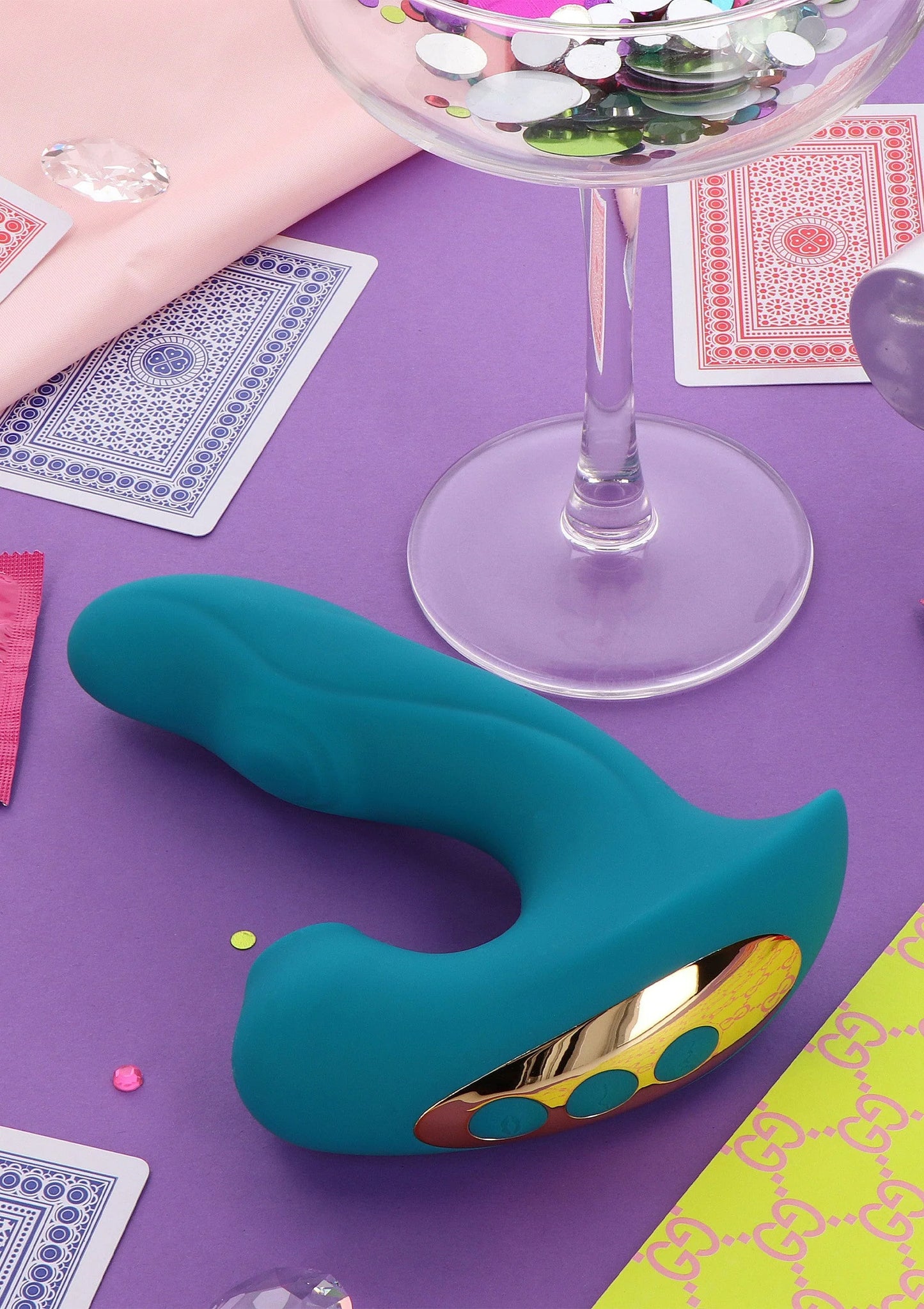 Teal vibrator met gouden onderplaat en ovale inzet met stippen op de kop.