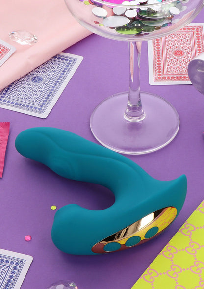 Teal vibrator met gouden onderplaat en ovale inzet met stippen op de kop.