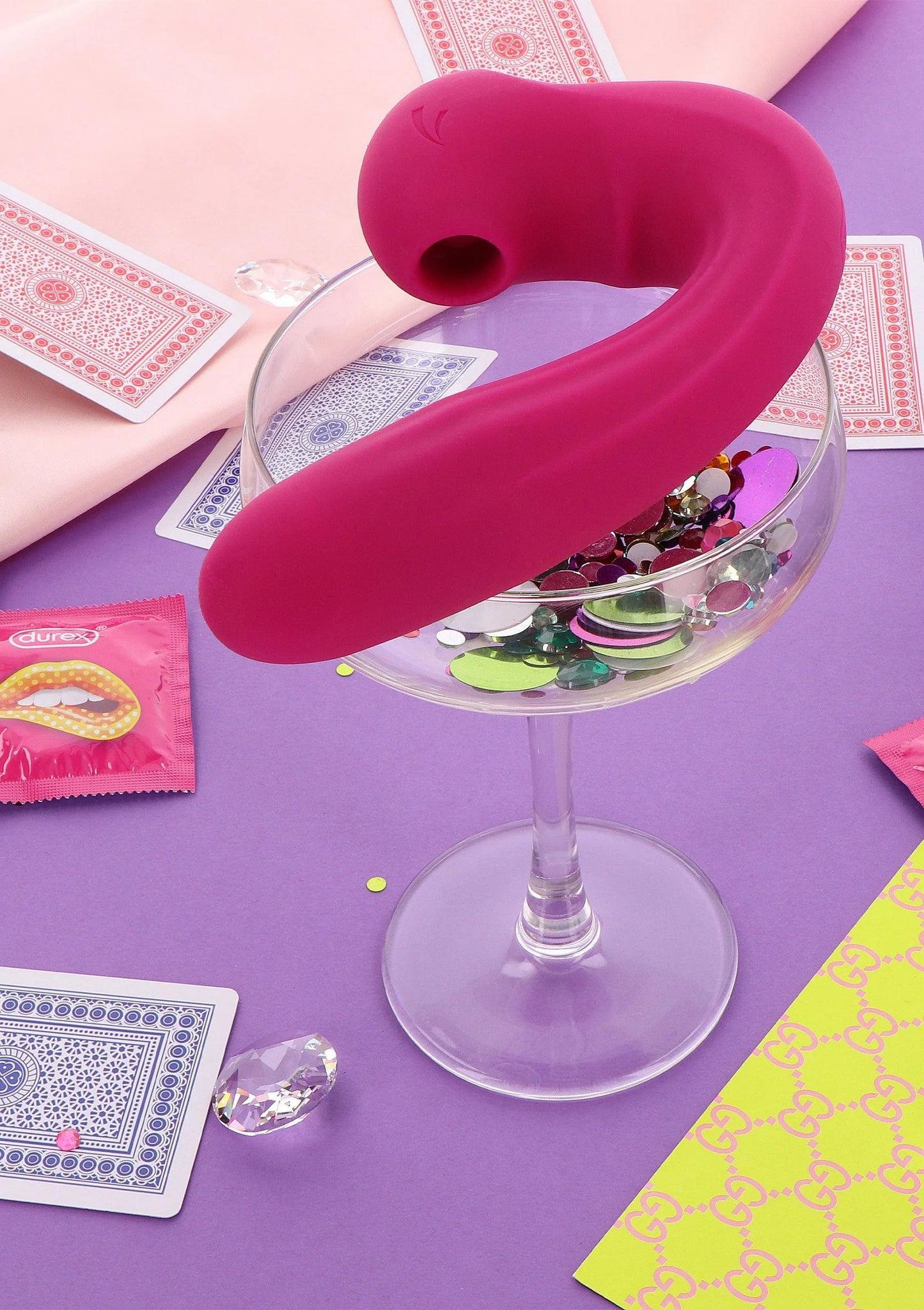 Roze clitorisvibrator op tafel, gebogen vorm met ronde kop en zichtbare opening