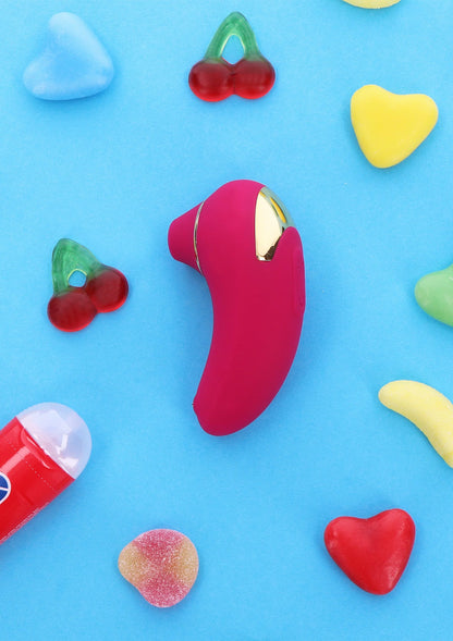 Roze handheld clitorisstimulator met gouden ring, onderaan enkele knoppen zichtbaar