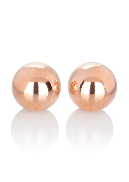 Twee rose-gouden gewogen kogels, ronde spiegelende balletjes.