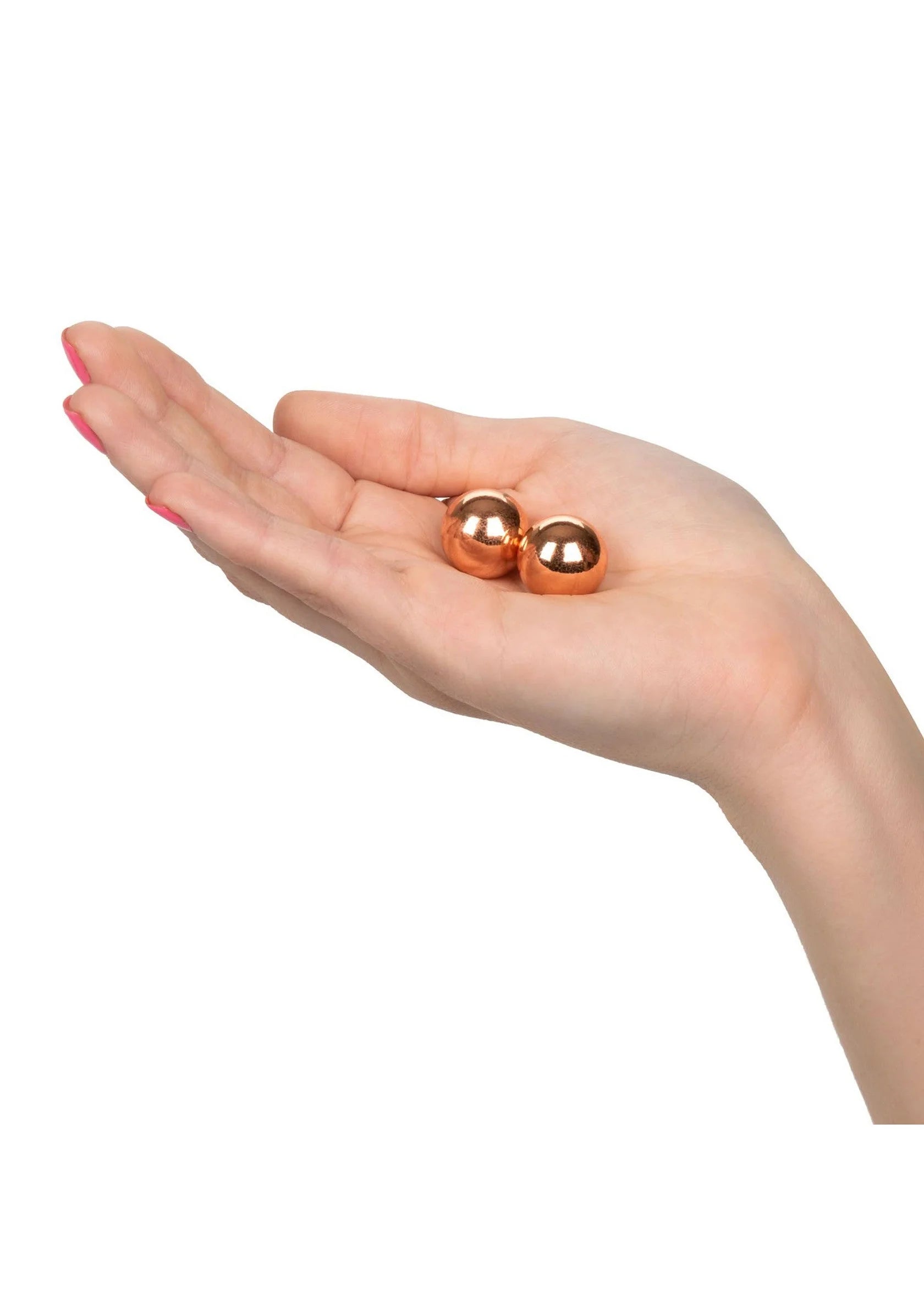 Rose-gouden gewogen kogels in open hand, twee kleine ronde balletjes.
