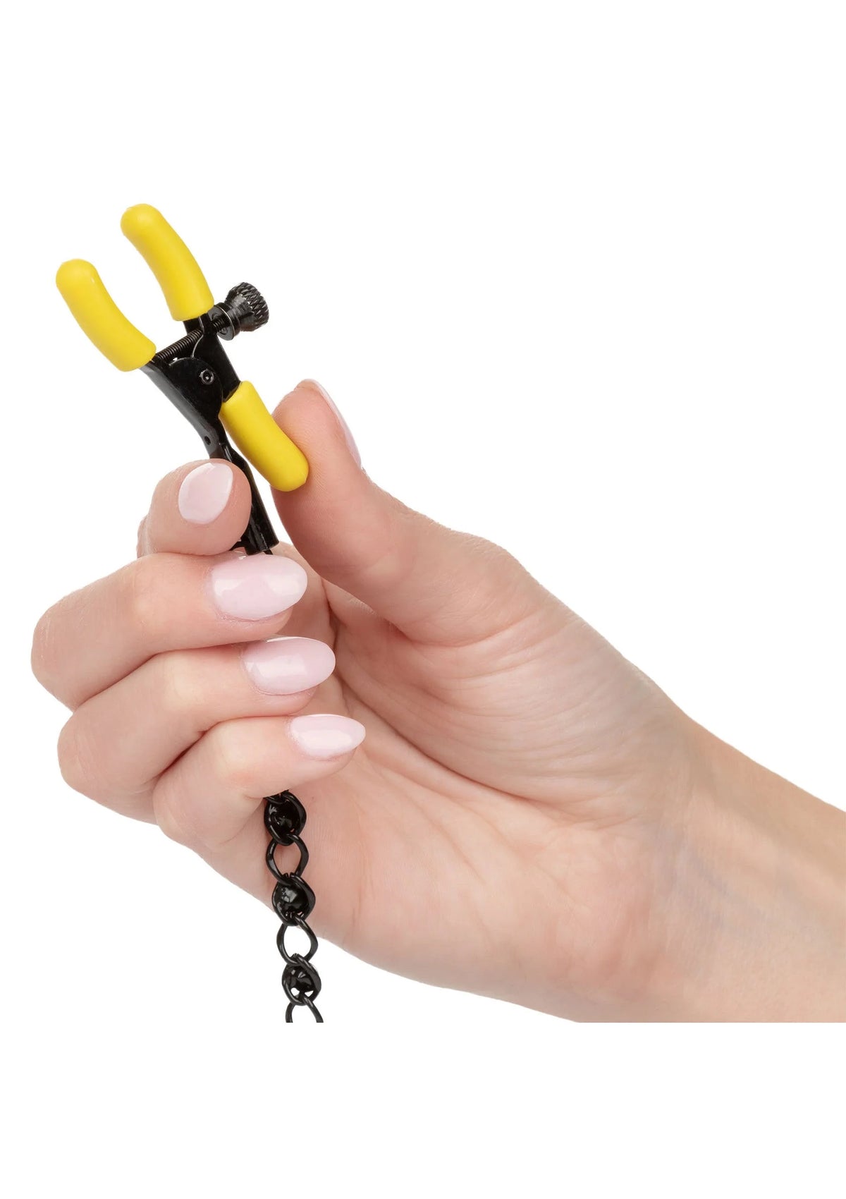 Gele en zwarte niet-perforerende borstnippelclip met ketting, in de hand vastgehouden