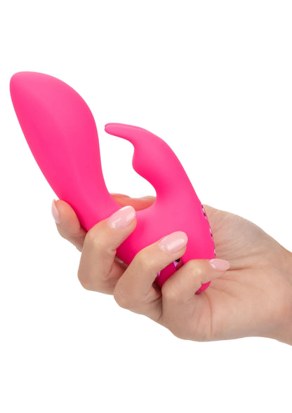 Roze siliconen vibrator vastgehouden in hand, gebogen vorm met holle opening