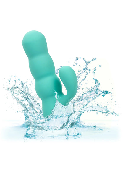 Turquoise gebogen seksspeeltje in water met spetters rond de basis