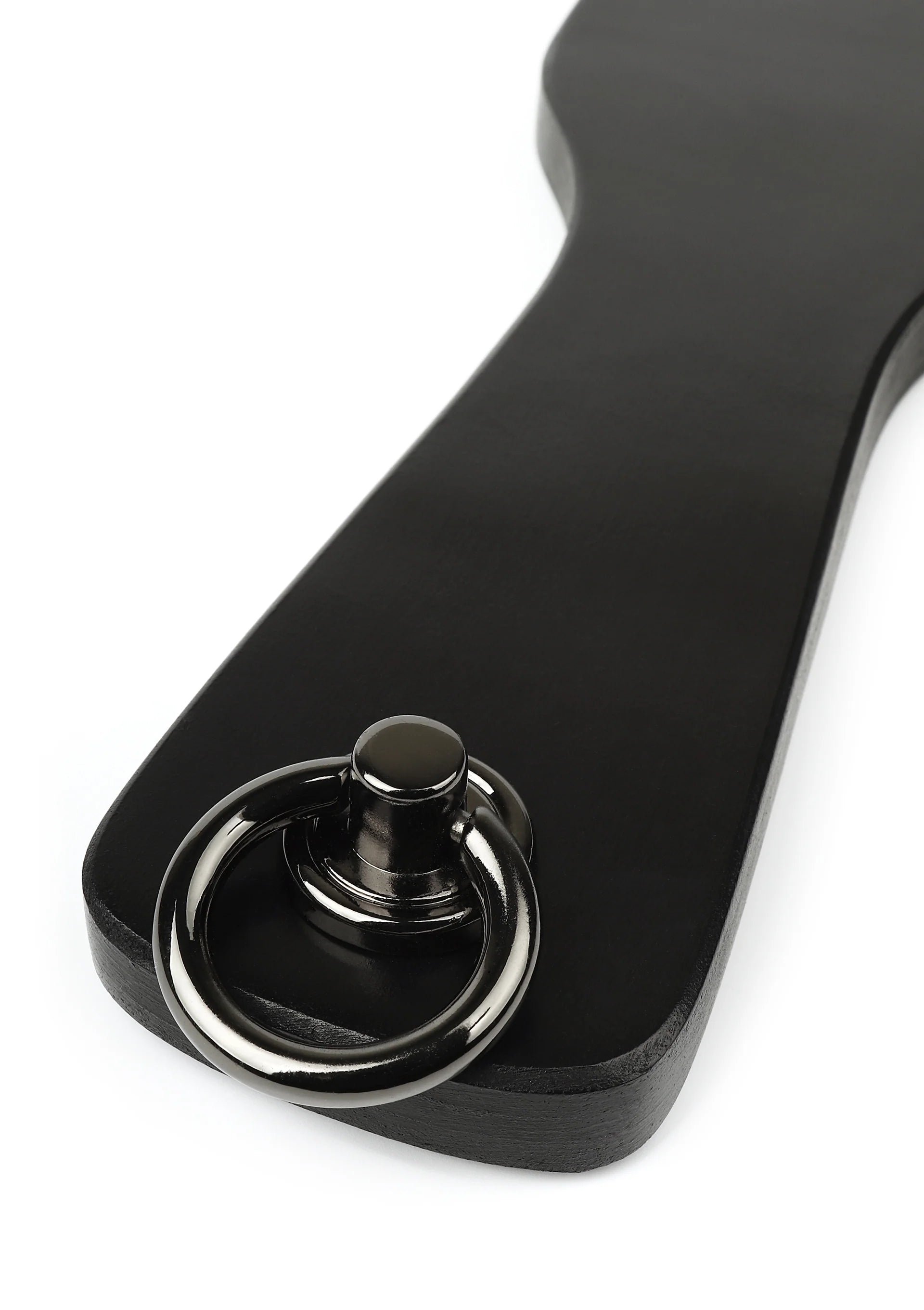 Spankpeddel van echt leer, zwart met ronde metalen ring en knoop, close-up