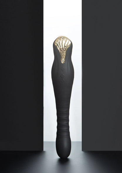 Zwarte dildo met goudkleurige kop en glanzende ribbels aan de bovenkant.
