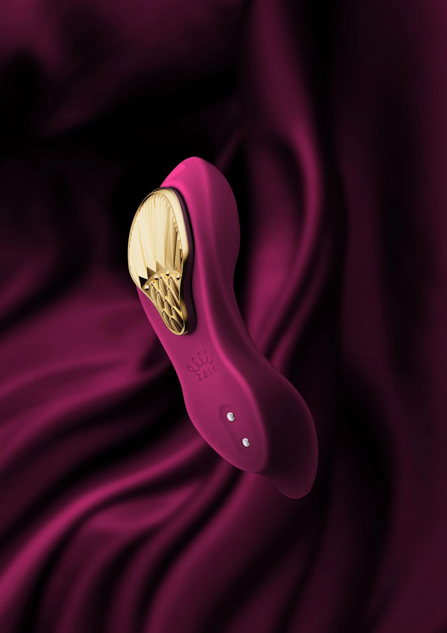 Draagbare vibrator Zalo bordeauxrood, close-up van gouden binnenkant en knoppen.
