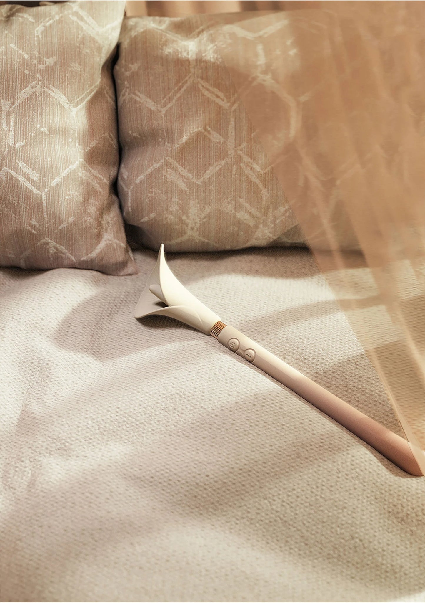 Witte Calla-trilstimulator op bedtextiel met bloemkop en lang handvat