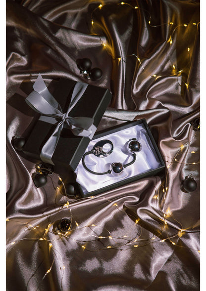 Zilveren pleasure balls met zwart koord op zilvergrijze satin