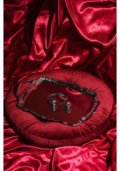 Zilveren metalen pleasure balls met zwart koord op rood satijn