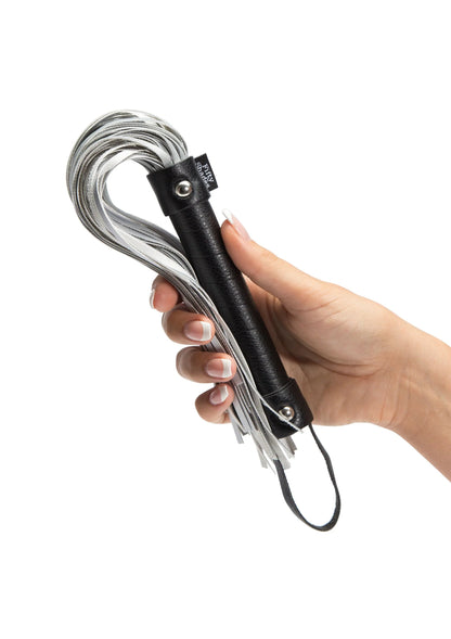 Close-up: handzweep met zwart handvat en zilveren franjes, in hand vast