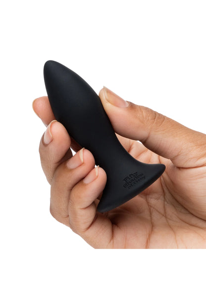Zwarte buttplug vastgehouden in hand, taps toelopende vorm met afgeronde top