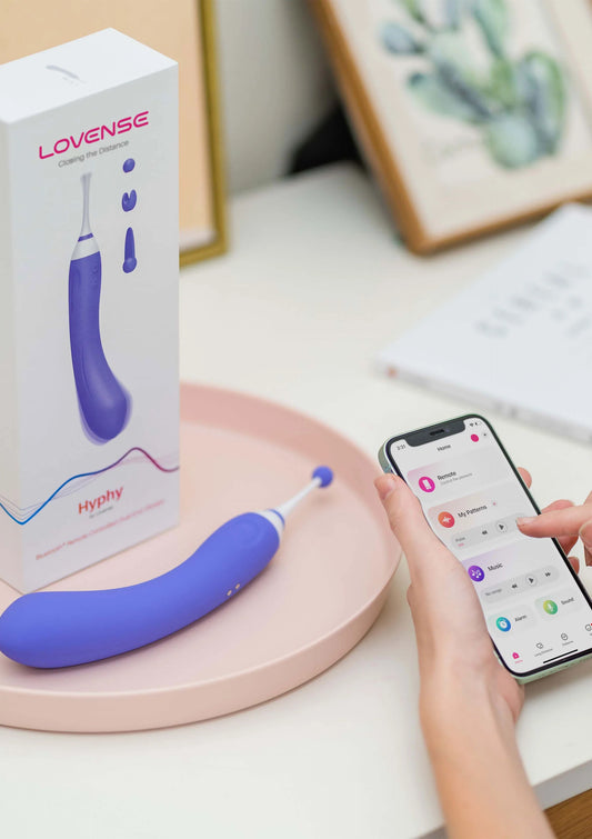 Blauwe Hyphy-vibrator op tafel, met doos en smartphone met app-bediening in beeld.