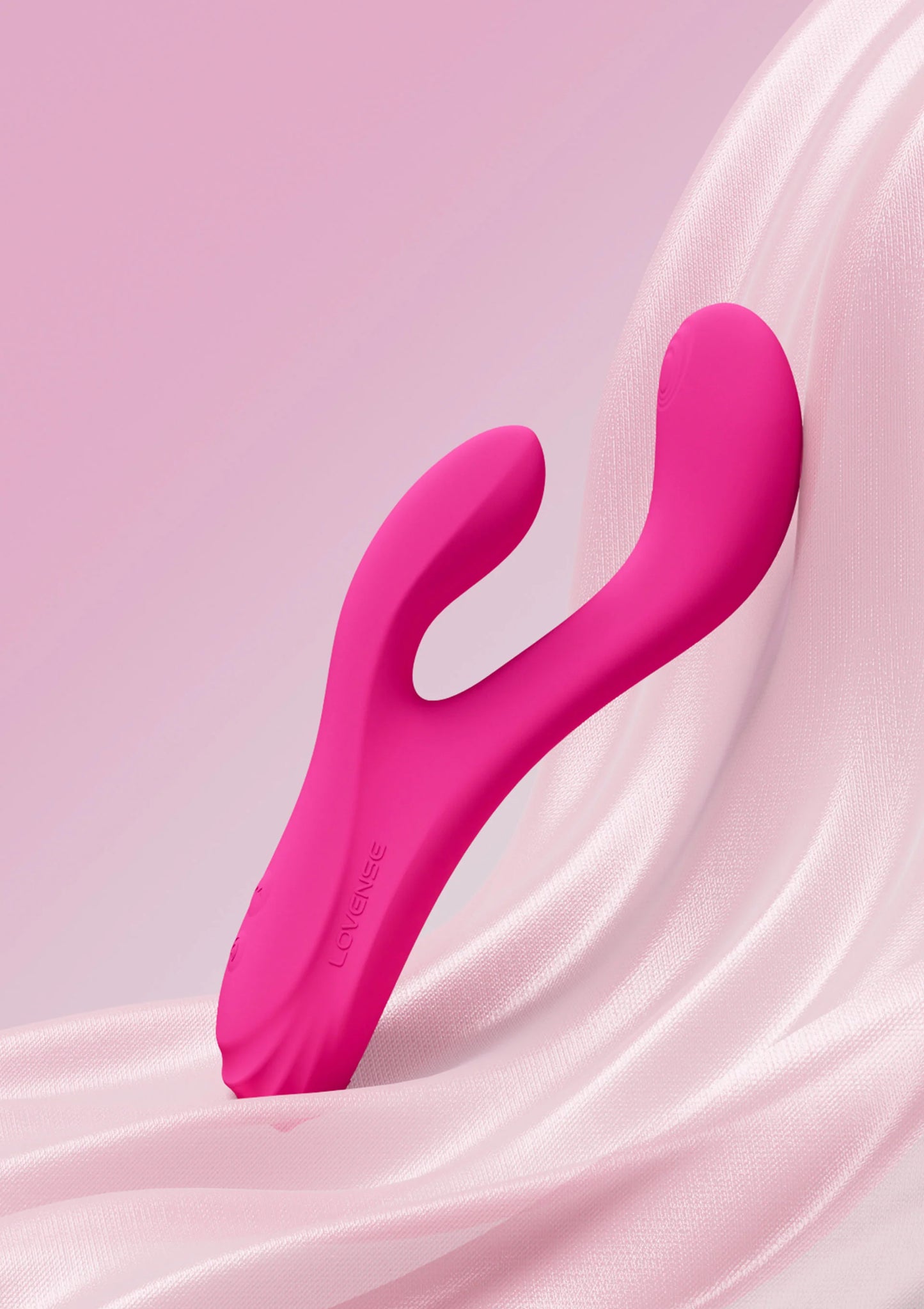 Roze U-vormige vibrator op lichtroze stof met glanzende textuur