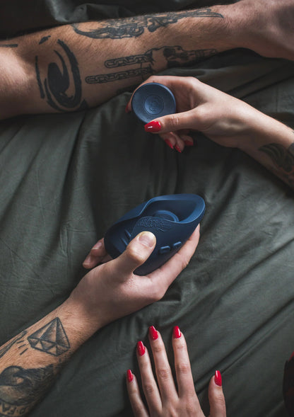 Blauwe afstandsbediening met knoppen en blauwe vibrator in de hand