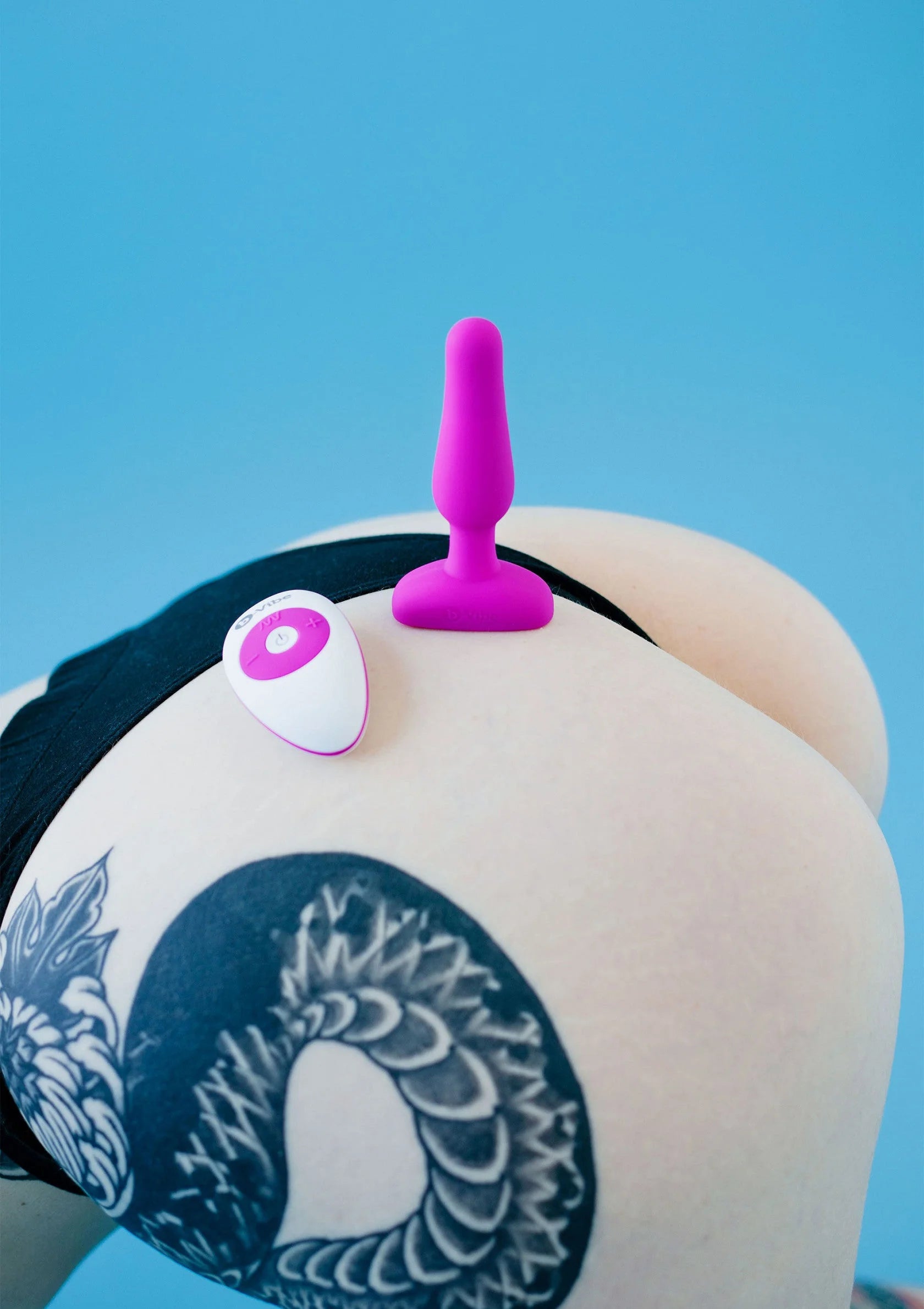 B-Vibe novice plug in fuchsia op het lichaam, bovenaan zichtbaar