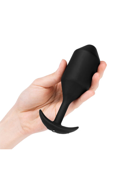 Vibrerende anale plug XXL zwart in hand, met korte steel en brede flens.