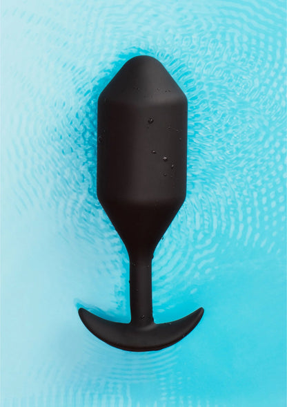 Zwarte vibrerende anale plug XXL met druppels, in blauw waterbeeld.