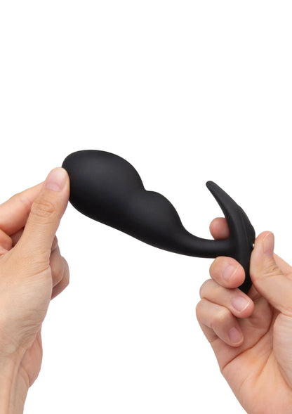 Zwarte P-spot plug met gebogen vorm en brede basisflens, tussen twee handen